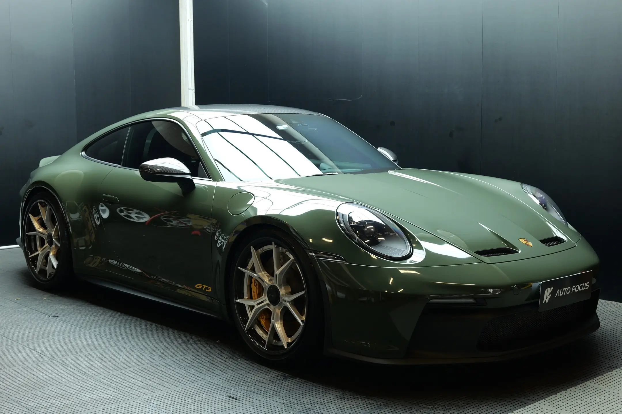 Porsche 911 wrapped in Black Olive vinyl, carbon wheels, front bumper PPF and bonnet protection.